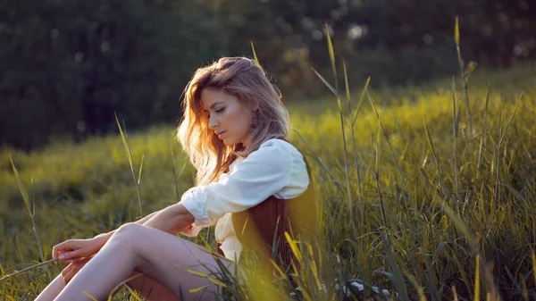 Mulher bonita desfrutando de um piquenique na natureza. Menina sentada na grama, descanso, relaxamento — Fotografia de Stock