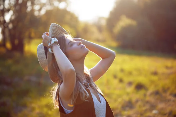 Leuk charmant meisje in de zomer in het veld. Jonge vrouw is blij en voelt gratis buitenshuis — Stockfoto