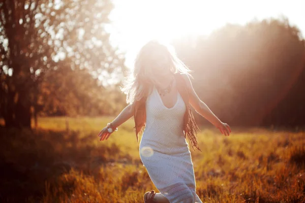La chica se está acabando. Mujer joven en el campo, sentir la libertad y la felicidad. Estilo casual . — Foto de Stock