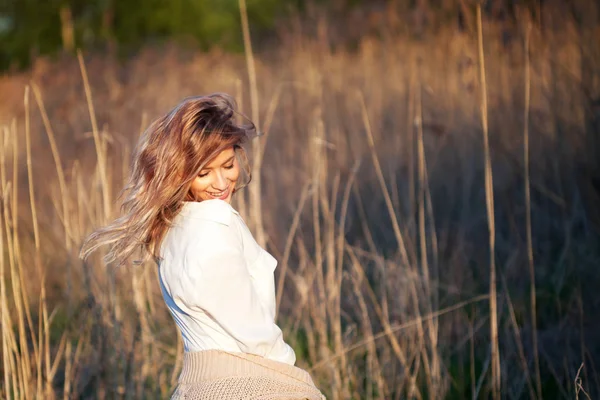 Leuk charmant meisje in de zomer in het veld. Jonge vrouw is blij en voelt gratis buitenshuis — Stockfoto