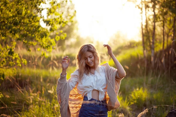 Счастливая молодая женщина наслаждается прекрасным вечером. Теплая погода, лето, поле — стоковое фото