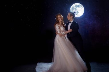 Gizemli ve romantik bir buluşma, gelin ve damat ayın altında. Birlikte sarılmak. Karışık teknik