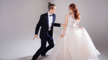 Gülüyor ve birlikte dans olumlu genç bir çift. Çift Studio hafif bir arka plan.