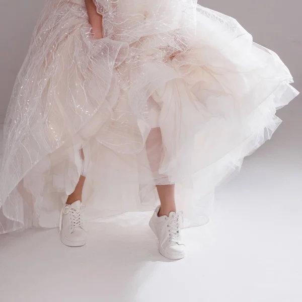 壮大な結婚式のドレスと白いスニーカーの女の子は開脚クローズ アップです。プリティ ・ ブライド — ストック写真
