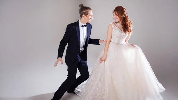 Positives junges Paar, das zusammen lacht und tanzt. das Paar im Studio vor hellem Hintergrund. — Stockfoto
