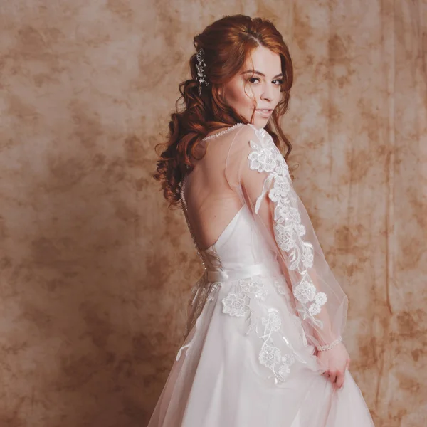 Красивая и романтичная невеста в свадебном платье с длинными рукавами. Молодая рыжая женщина в свадебном платье — стоковое фото