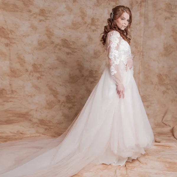 Mooie en romantische bruid in trouwjurk met lange mouwen. Jonge roodharige vrouw in trouwjurk — Stockfoto