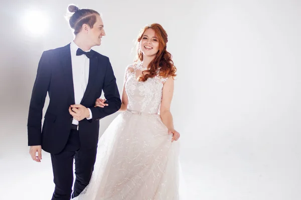 Marido e mulher sorrindo um para o outro. Um jovem casal positivo. O casal no Estúdio um fundo leve . — Fotografia de Stock