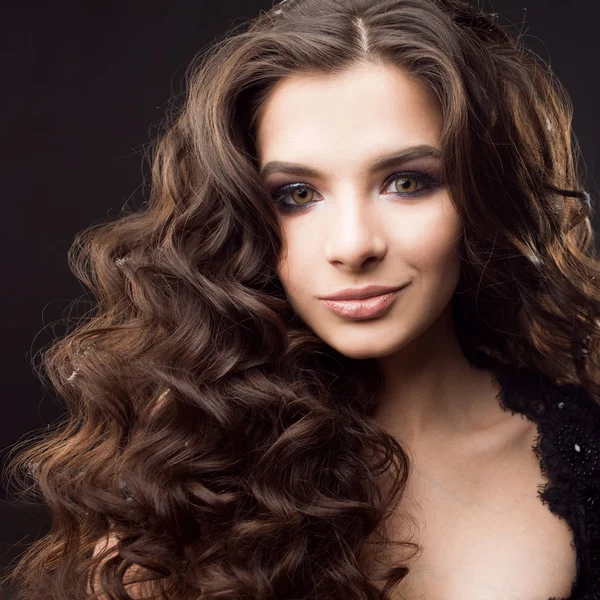 Retrato de una joven atractiva con un hermoso cabello rizado. Atractiva morena —  Fotos de Stock