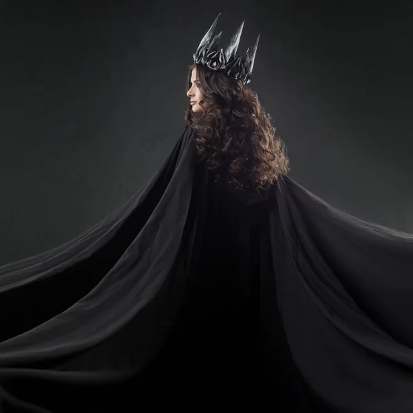 一个哥特式公主的肖像。在金属冠和黑斗篷美丽的年轻黑发妇女. — 图库照片