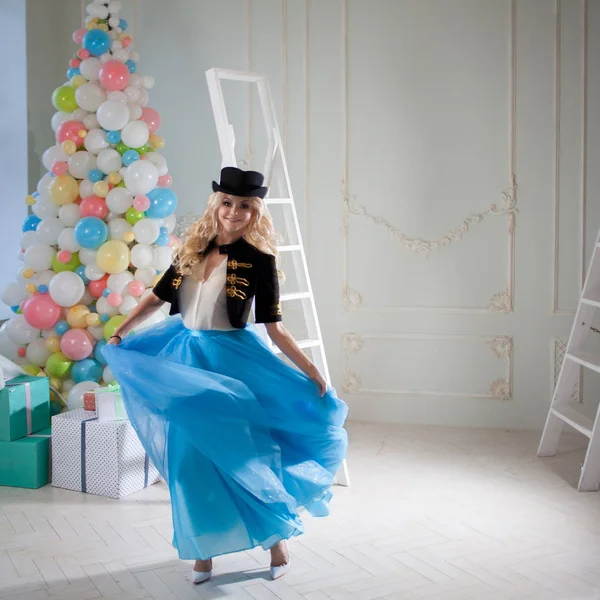 Leuke en mooie blonde in een prachtig interieur. Charmante jongedame in een bochtige blauwe rok. — Stockfoto