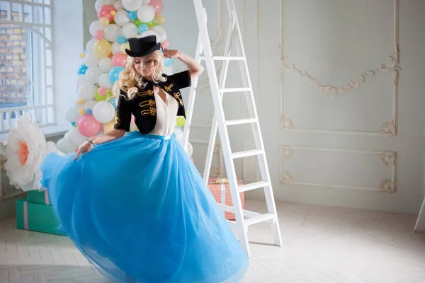 Leuke en mooie blonde in een prachtig interieur. Charmante jongedame in een bochtige blauwe rok. — Stockfoto