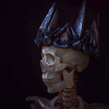 The skull in crown. Grim necromancer in Gothic crown. Black background, Halloween concept clipart