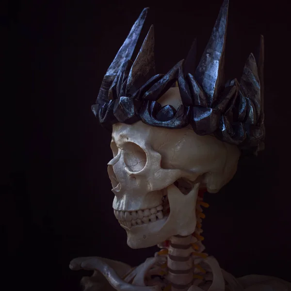 Den Totenkopf in der Krone. grimmiger Totenbeschwörer in gotischer Krone. schwarzer Hintergrund, Halloween-Konzept — Stockfoto