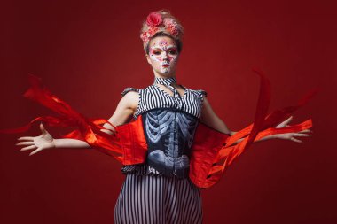 Kafatası makyaj ile genç güzel kadın. Uzanmış silah gösterir o içinde bulunur