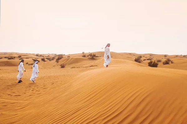 Dunes dans le désert, sable. Au loin, il y a des hommes en costume national arabe — Photo