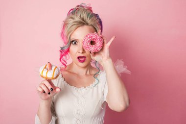 Renkli saç ile şık ve güzel bir kadın. İki donut gözlük, komik yüz buruşturma olarak