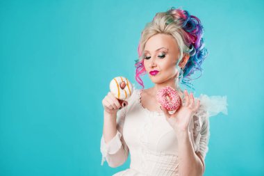 Renkli saçlı güzel genç kadın. İki tatlı çörek, komik tutar