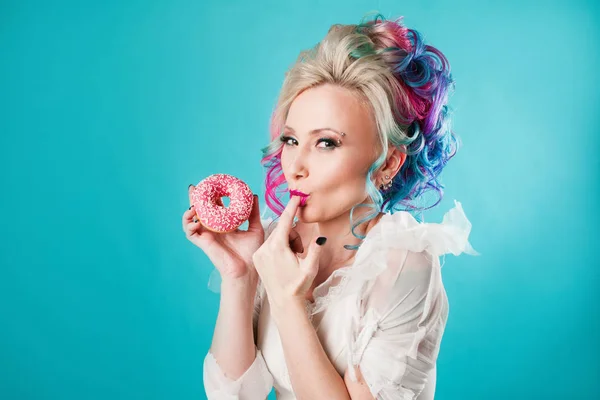 Cool mujer joven con el pelo de color, sabor donut dulce, divertido —  Fotos de Stock