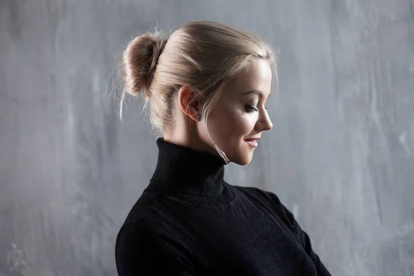 Portret van mooie blonde vrouw. Rust en zelfvertrouwen. Mooi volwassen meisje in zwarte coltrui, grijze achtergrond — Stockfoto