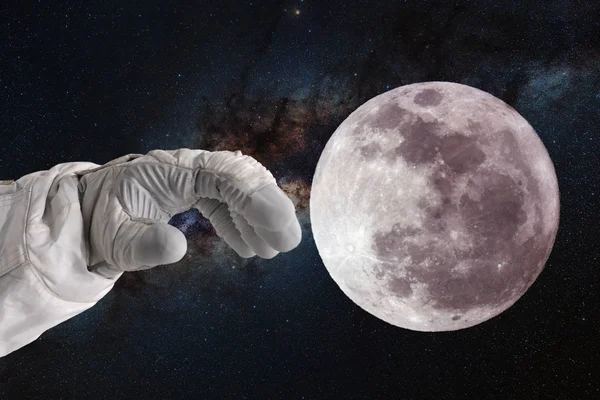 Desenvolvimento da lua, conceito. Mão de astronauta astronauta puxa a mão para a lua . — Fotografia de Stock