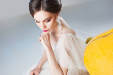 Güzel ve şık gelin gelinlik Studio bir sandalyede oturuyor