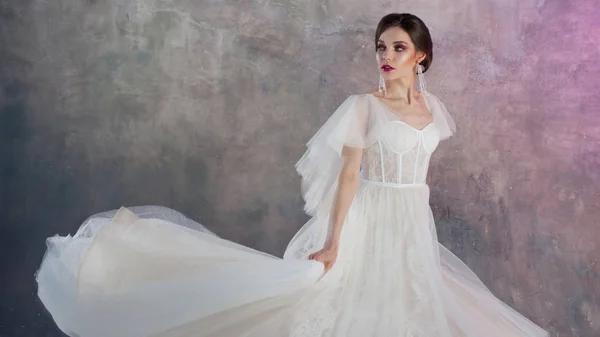 Bella ed elegante sposa in abito da sposa in Studio su sfondo grigio strutturato — Foto Stock