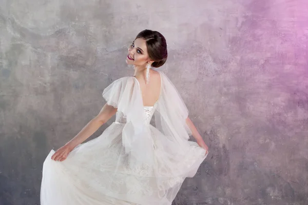 グレー テクスチャ背景のスタジオでウェディング ドレスで美しく、スタイリッシュな花嫁 — ストック写真