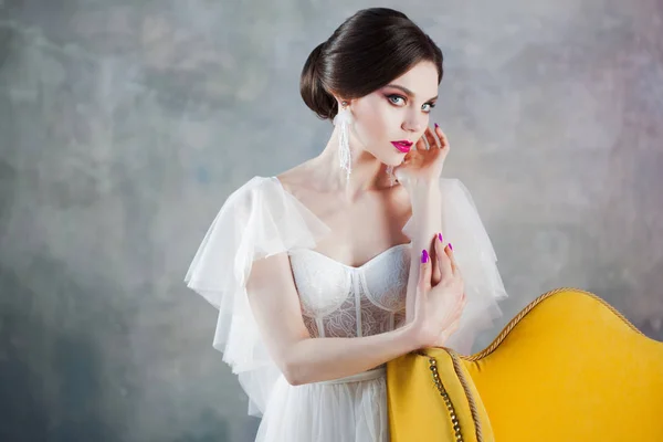 Vacker och elegant brud i brudklänning i Studio nära stolen — Stockfoto