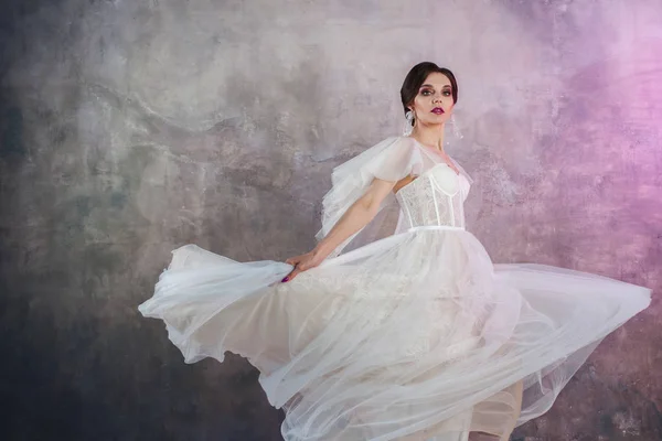 Bella ed elegante sposa in abito da sposa in Studio su sfondo grigio strutturato — Foto Stock