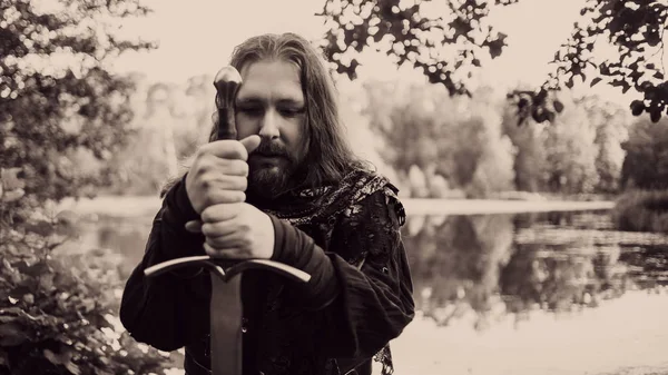 Ormanın içinde şövalye. Adam kılıçla Ortaçağ kostüm.