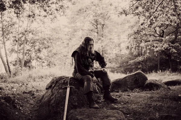 Ormanın içinde şövalye. Adam kılıçla Ortaçağ kostüm. tonlama etkisi