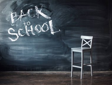 Siyah bir kara tahta üzerinde okul için oturum açın. Okul masa mektubu için karşı ahşap sandalye