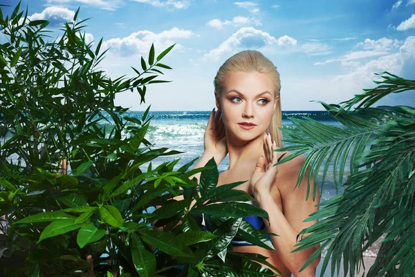 Schöne und charmante blonde Mädchen zwischen Palmen und tropischen Pflanzen. Glück, Ruhe auf dem Meer — Stockfoto