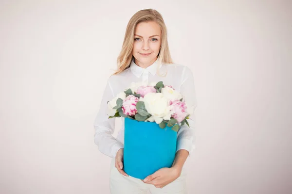 Stylish flower delivery, gift. Woman with flowers in a hat box. Bouquet of peonies. — Stock Photo, Image