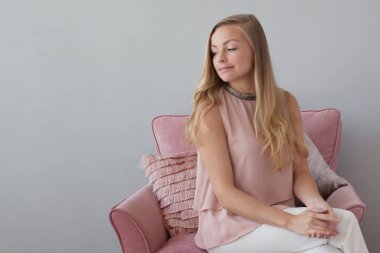 Genç dostu kadın bir defterde elleri ile bir sandalyede oturuyor. Güzel bir arkadaşı.