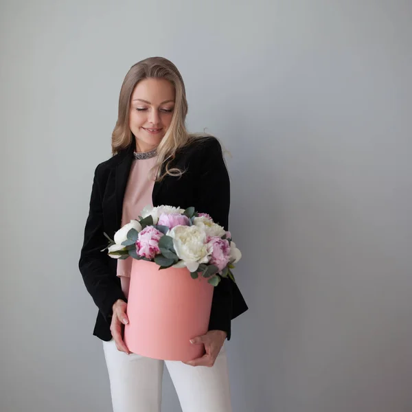 Charming blonde woman with flowers in a hat box. Bouquet of peonies. — Stock Photo, Image