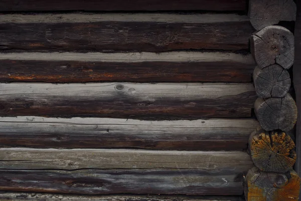 Tradições de construção de casas de madeira. Textura da parede de troncos. Fundo escuro — Fotografia de Stock