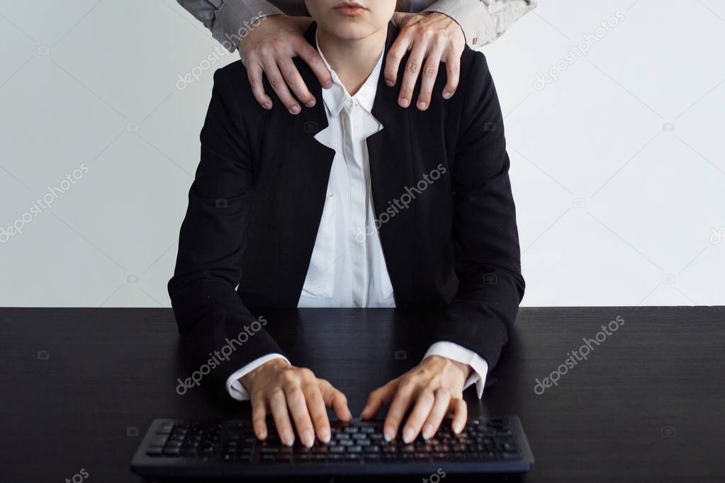Harassment in the work place, front view, concept. A man touches woman in the workplace.