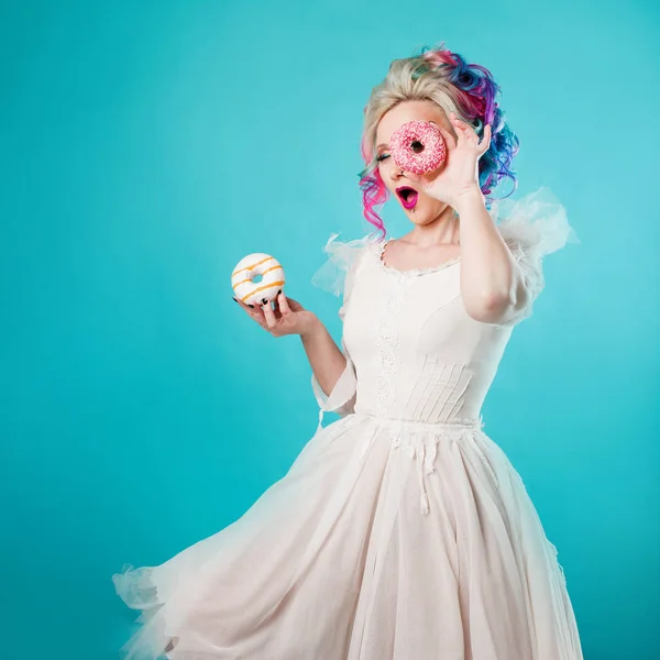 Mulher nova fresca com cabelo colorido. Segura dois donuts doces, engraçado — Fotografia de Stock