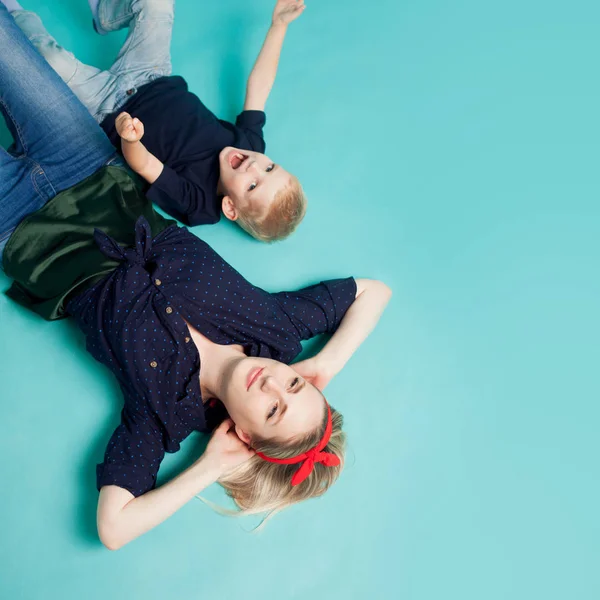 Família feliz. Jovem mulher loira bonita com filho divertido. Mentir, a vista de cima — Fotografia de Stock