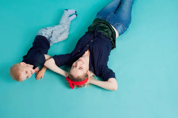 Família feliz. Jovem mulher loira bonita com filho divertido. Mentir, a vista de cima — Fotografia de Stock