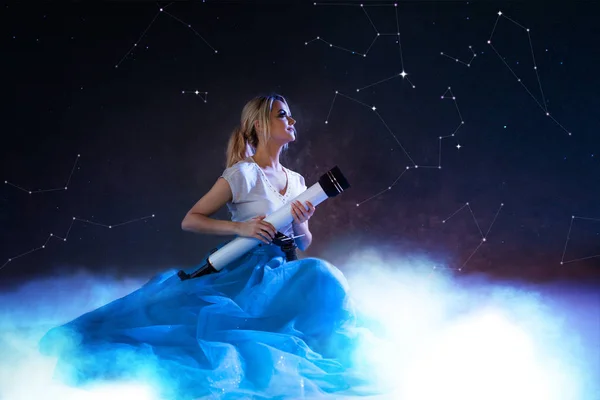 Mujer joven sueña con el futuro, concepto. Chica sobre las nubes mira hacia arriba y utiliza un telescopio. Cielo estrellado — Foto de Stock