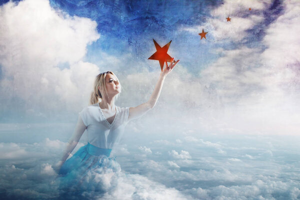 Молодая привлекательная женщина сидит на облаке и тянется к звезде. Возьмите звезду с неба, мечты и планы, концепцию
