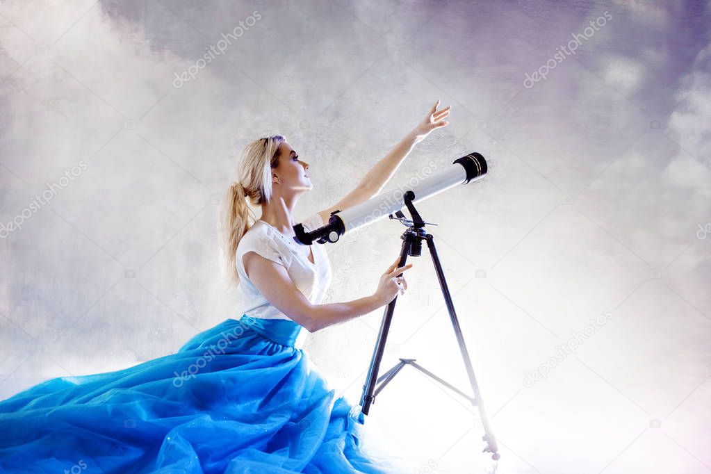 Young woman dreams of the future, concept. Girl in the sky with clouds looks up and uses a telescope.
