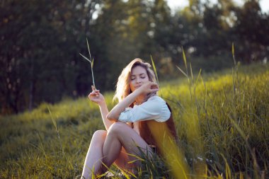 Doğada bir piknik keyfi güzel ve genç birbayan. Çim, dinlenme, rahatlama üzerinde oturan kız