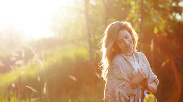 Милая очаровательная девушка летом в поле. Молодая женщина счастлива и чувствует себя свободно на открытом воздухе — стоковое фото