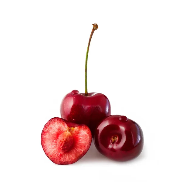 Sweet cherry isolerade på vitt. Tre saftiga mogna körsbär, en klippa i halv, inuti benet — Stockfoto
