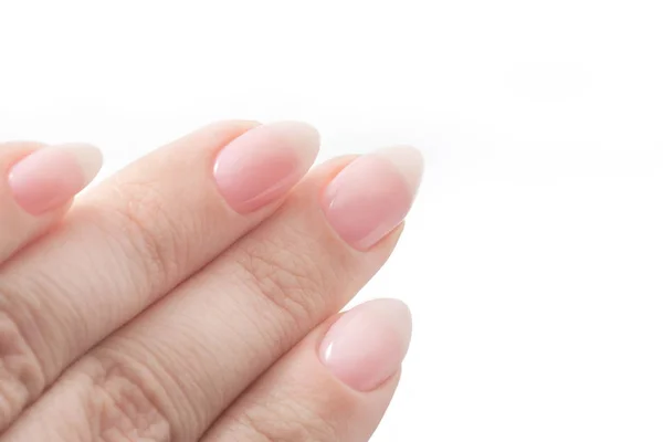 Les mains des femmes avec manucure parfaite Nu. vernis à ongles est une teinte rose pâle naturel. Isolé sur blanc — Photo