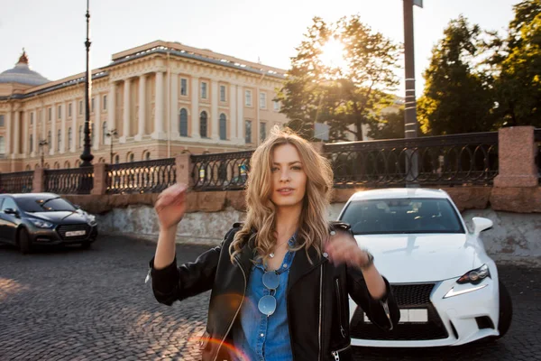 Красивая и стильная молодая блондинка. Портрет на заднем плане ее машины — стоковое фото